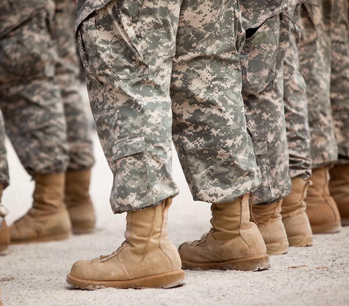 Rows of military personnel in military uniform with brown army boots.
